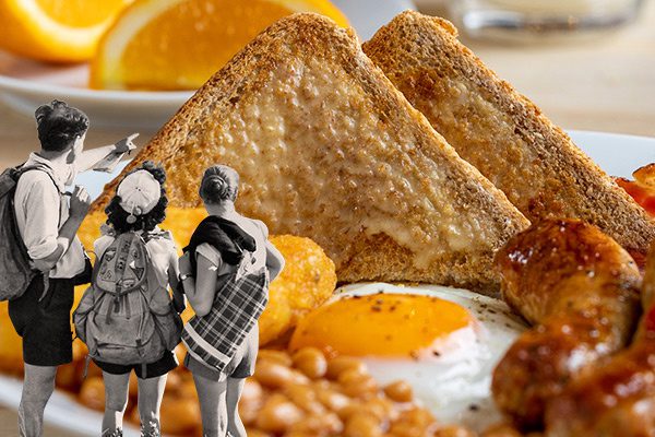 Group standing in front of a full English breakfast
